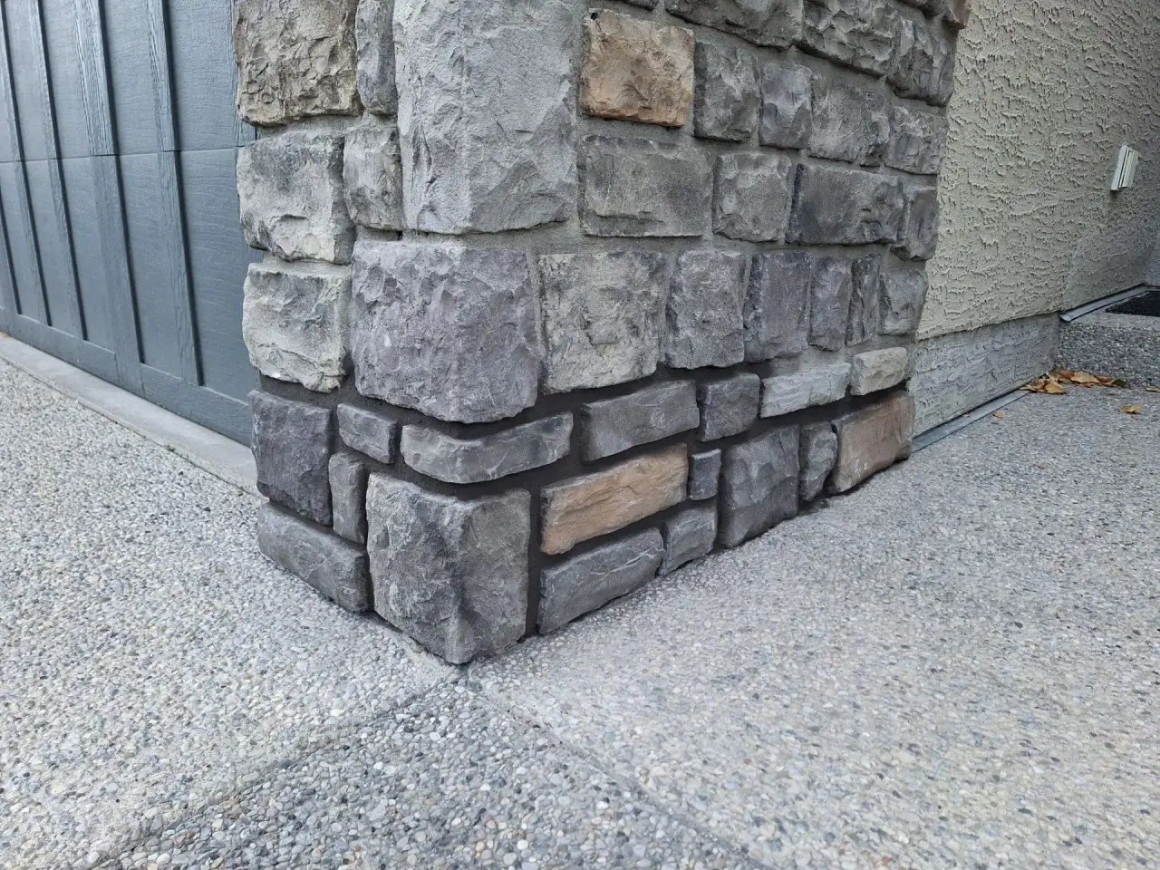Natural stone repaired at the garage wall base in Calgary