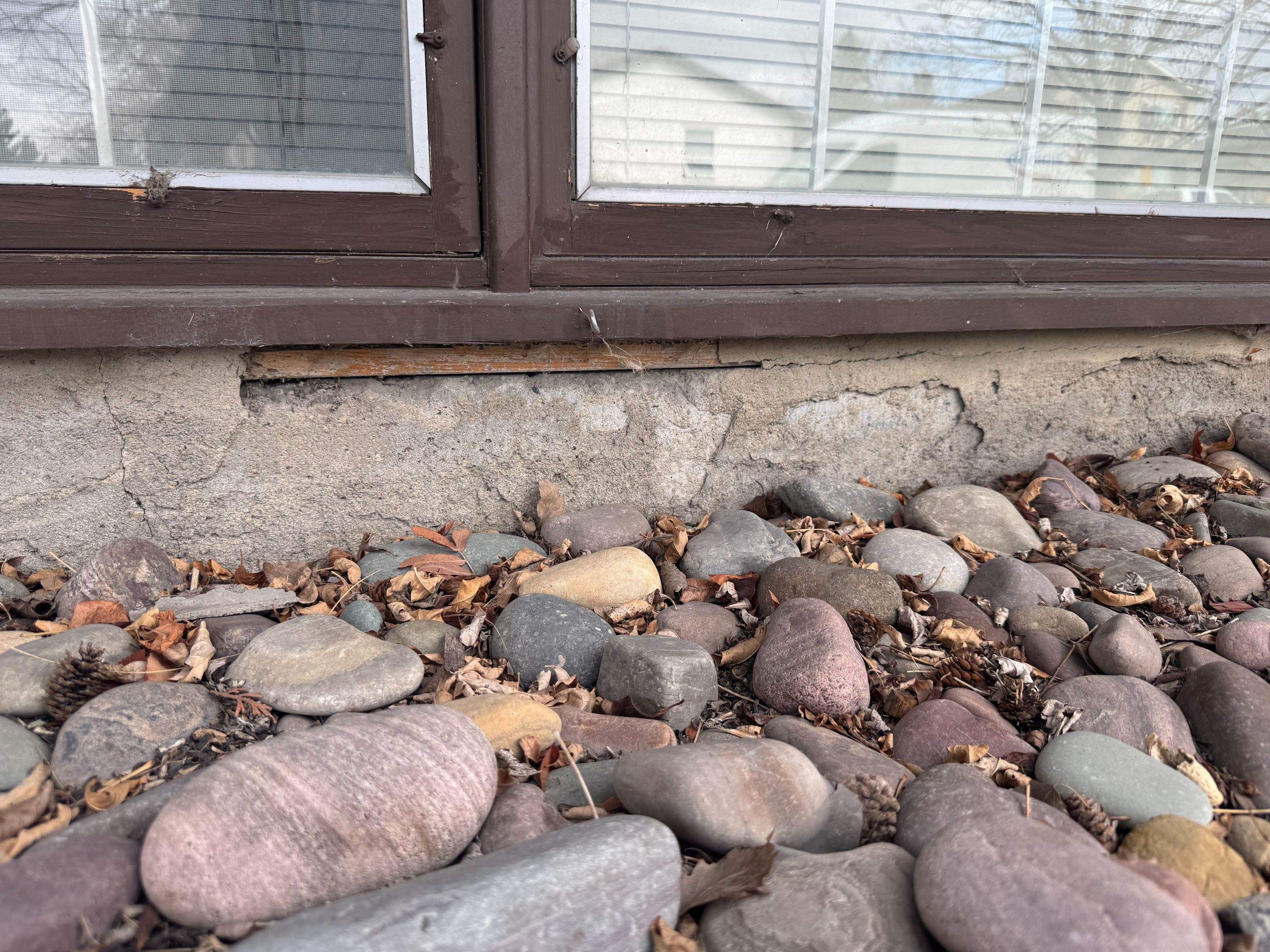 Deteriorated parging under a window before repair