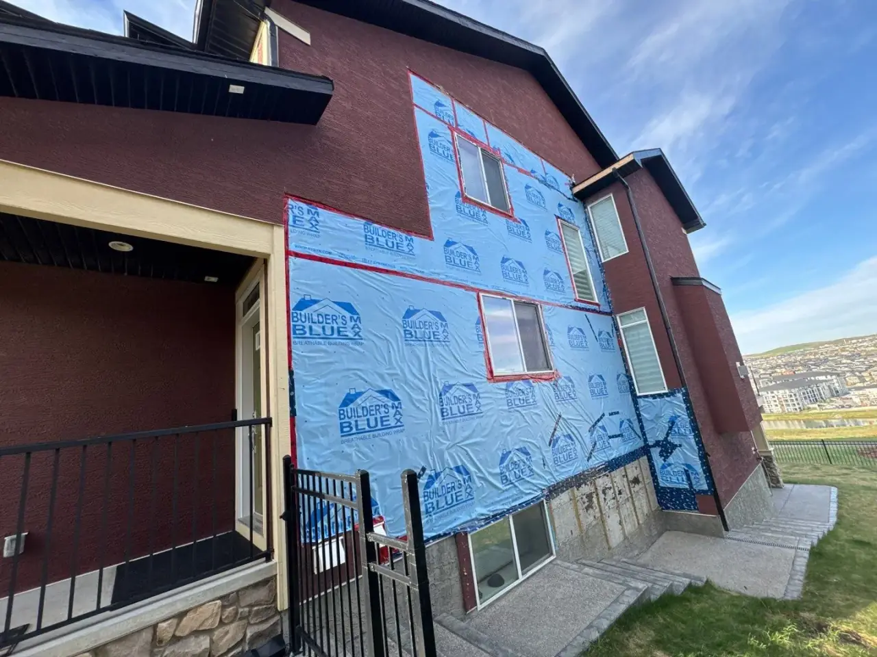 Right elevation of a Calgary home stripped to vapour barrier before stucco