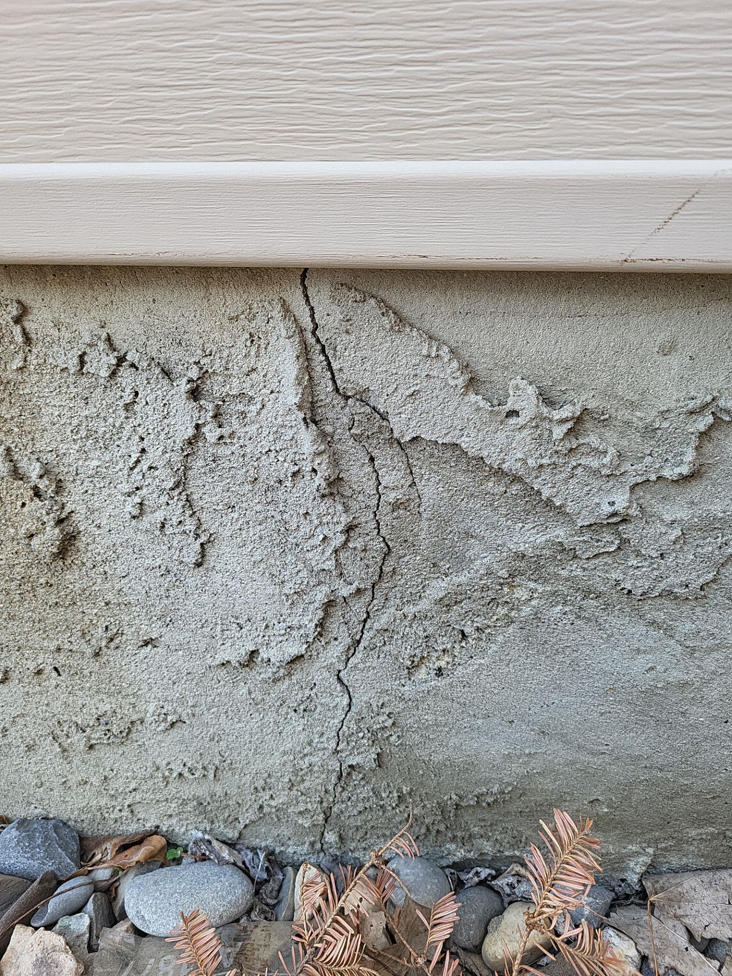 Vertical crack in old parging on a Calgary home