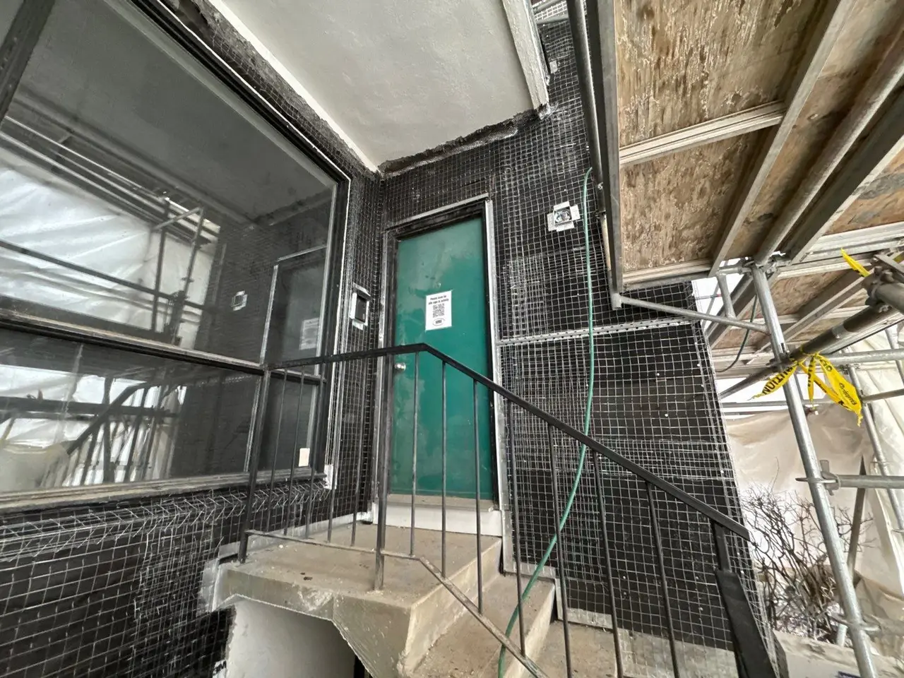 Wire lath installed over rainscreen strapping and cover board at an entry stair, ready to receive the Portland cement scratch coat