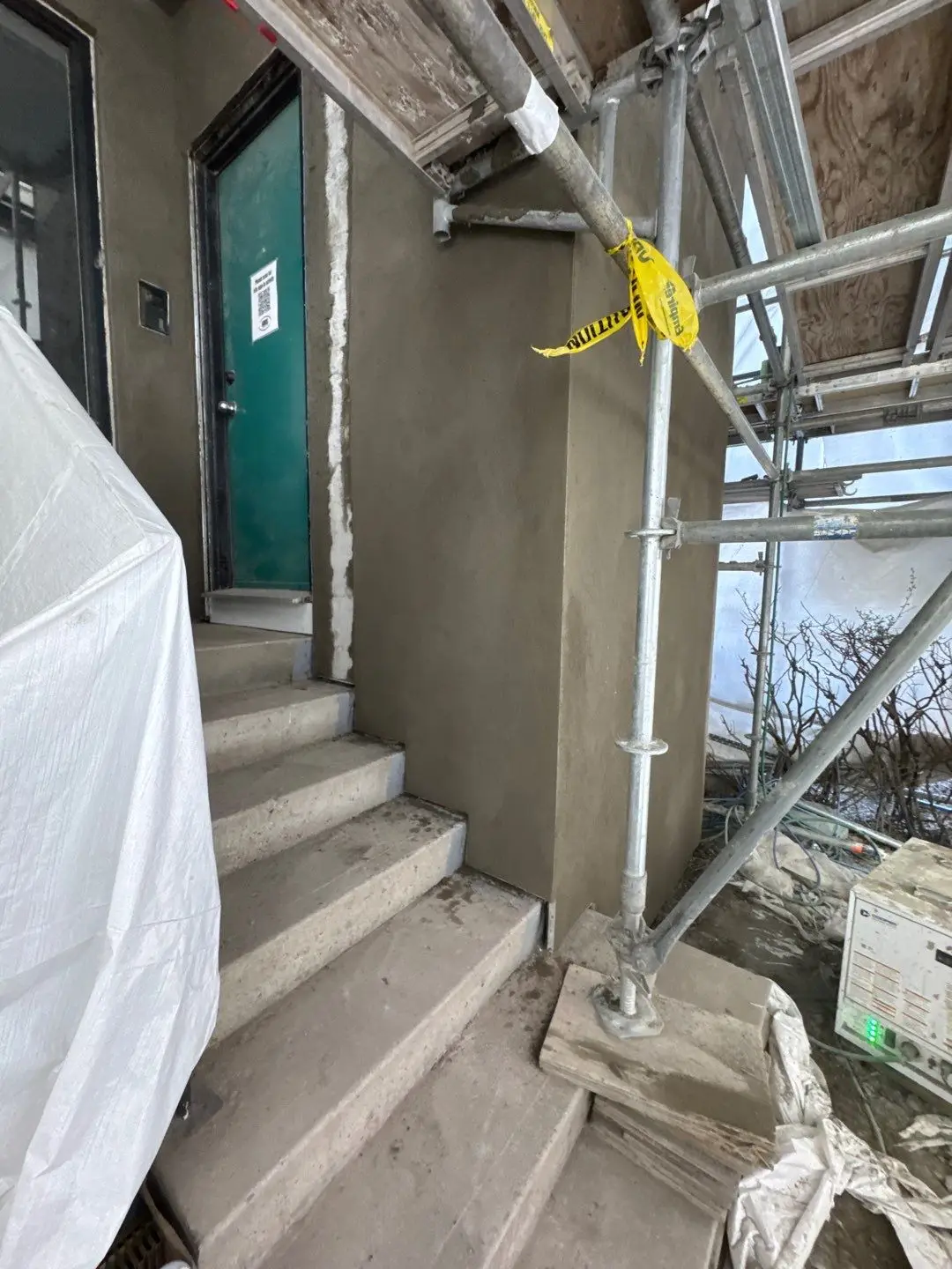 Portland cement brown coat applied to the front entry elevation, flat and true, before the acrylic finish coat