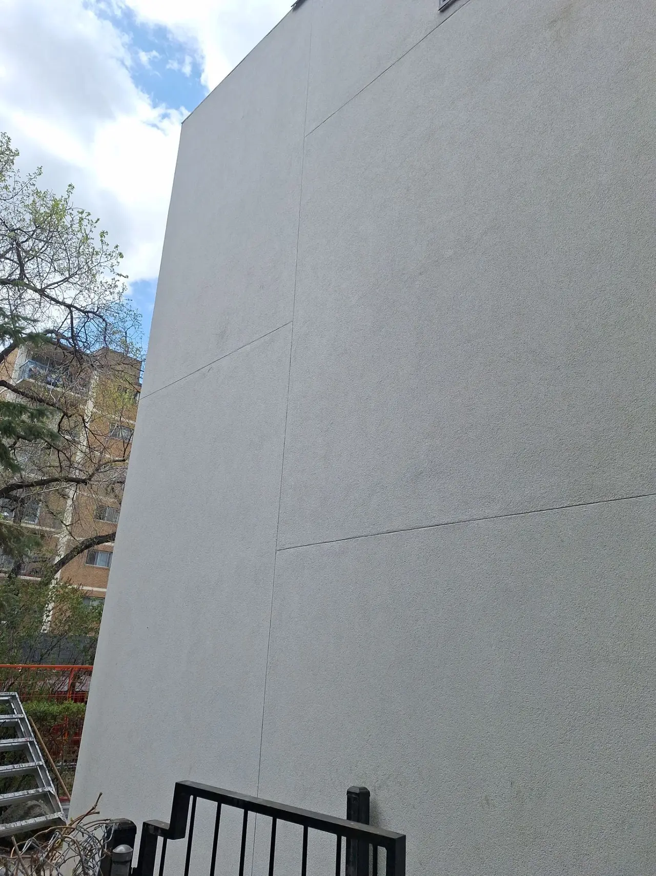 Finished floated acrylic stucco on the completed rainscreen elevation with control joints visible