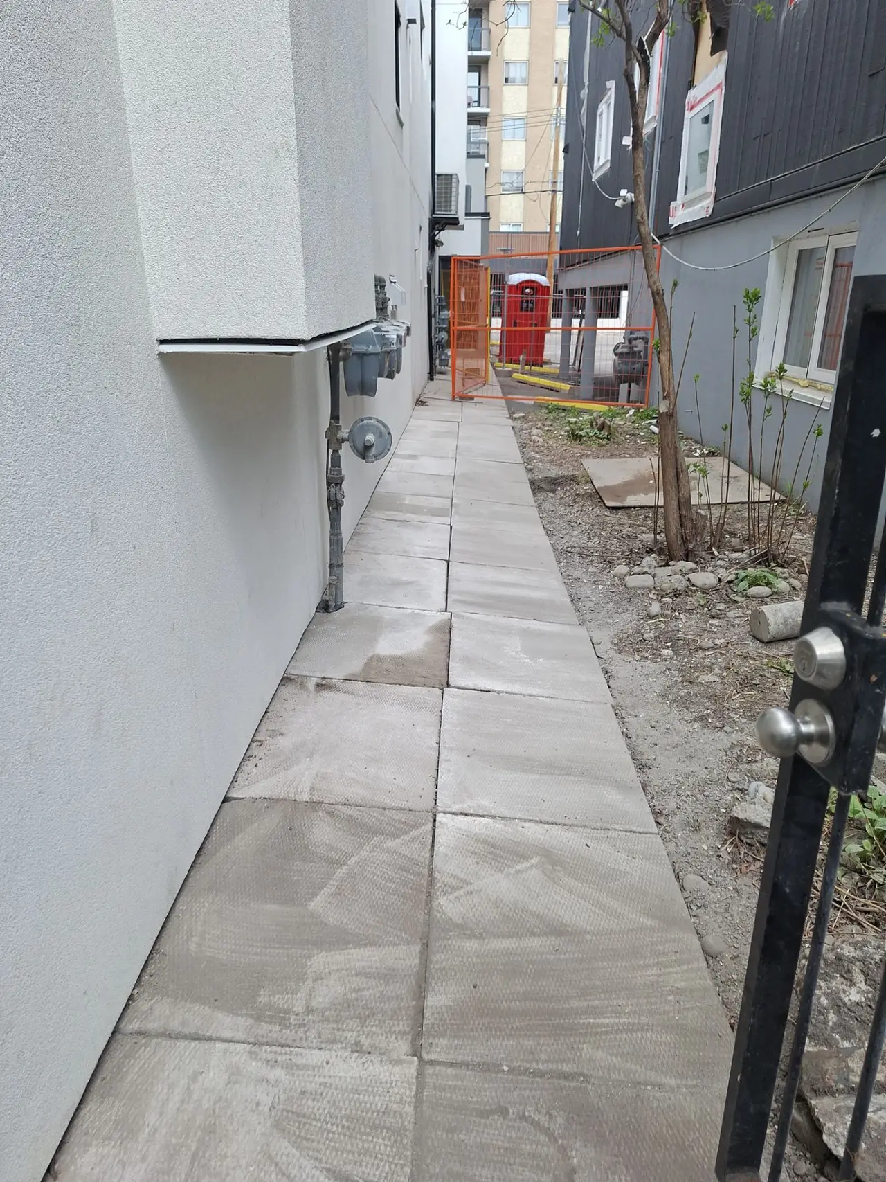 Completed stucco elevation with the adjacent walkway, block pavers and gas meters cleaned down after the job