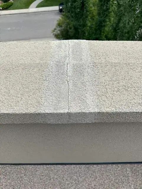 Cracked stucco on a parapet wall before repair