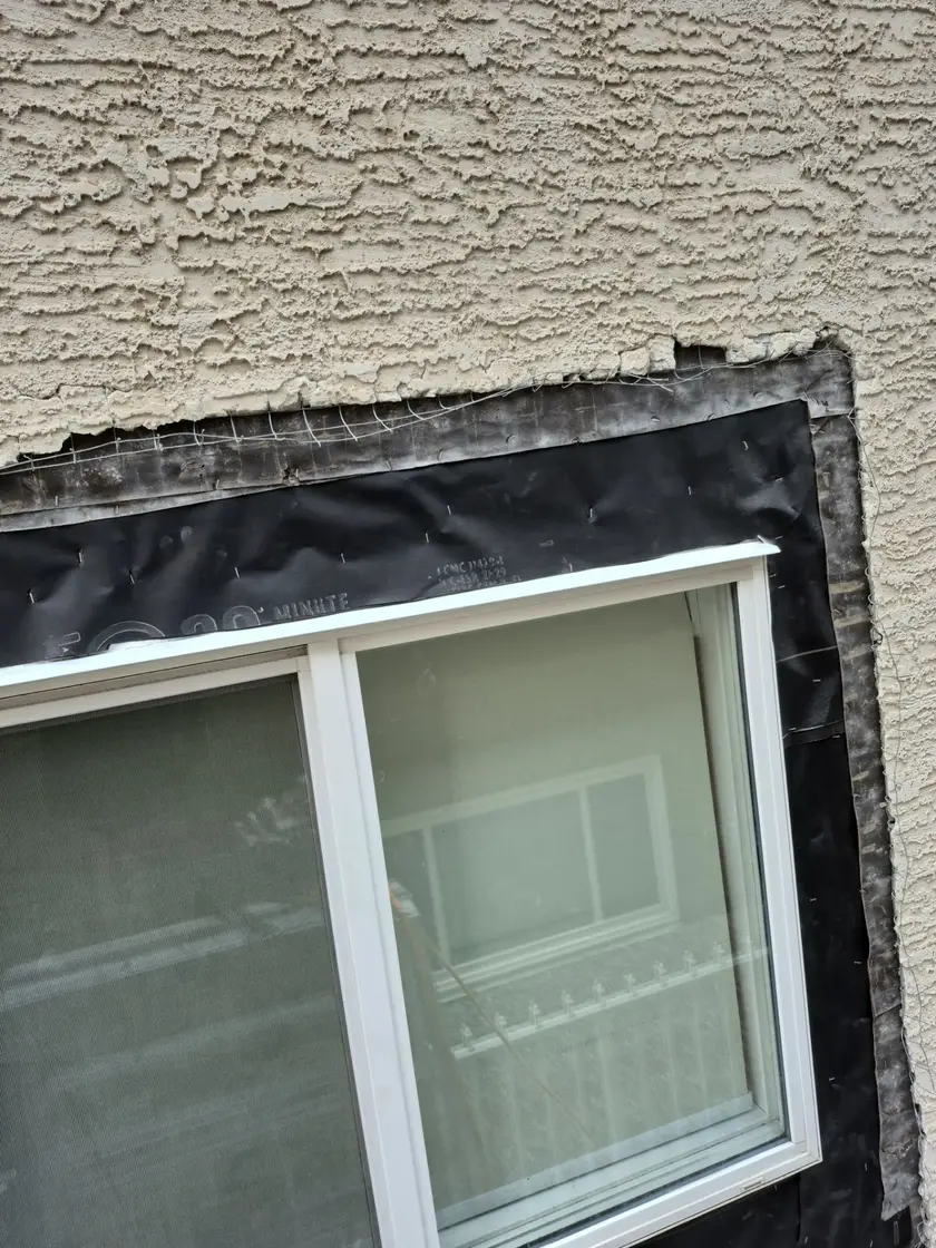 New black 30 minute building paper stapled and lapped over the existing paper above a window