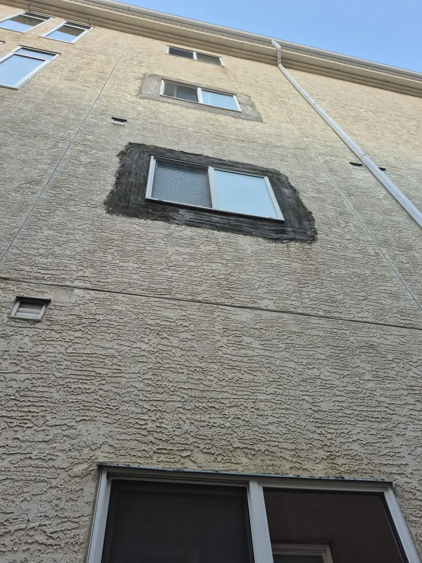 Elevation showing two window patches at different stages, dark scratch coat on the lower window and lighter brown coat on the upper